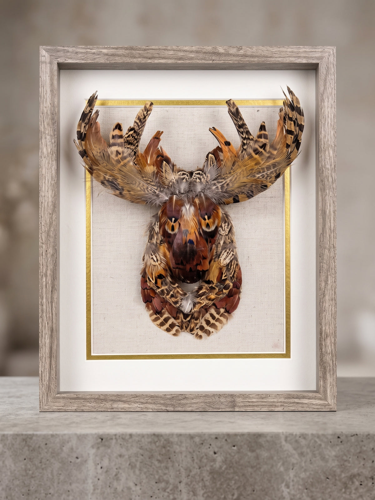 Feather art shadow box of a moose head and antlers in copper, rust and bronze pheasant feathers, in a grey wood frame